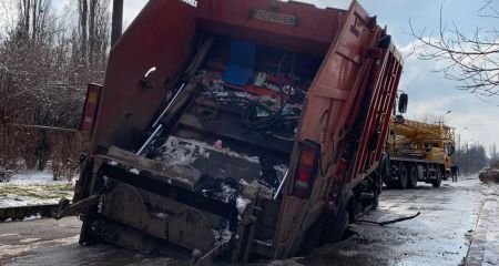 В Кривом Роге мусоровоз провалился в огромную дыру посреди дороги и застрял (ФОТО)